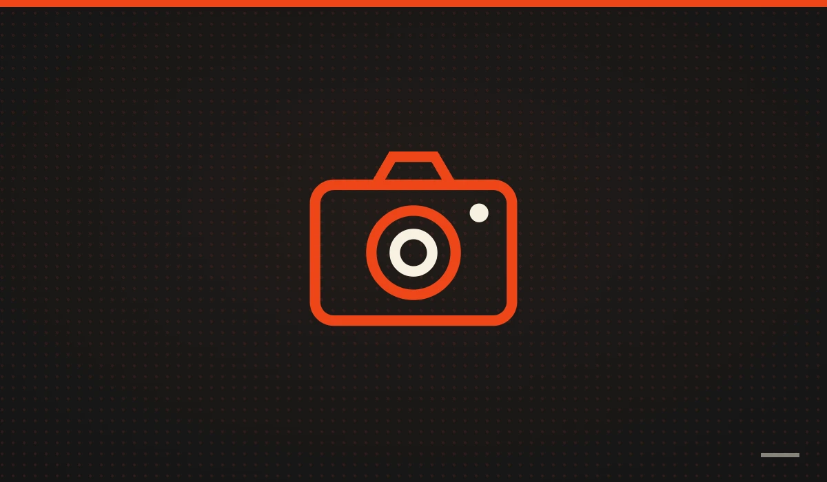 Cámara de fotos naranja sobre fondo negro: fotos para tu web