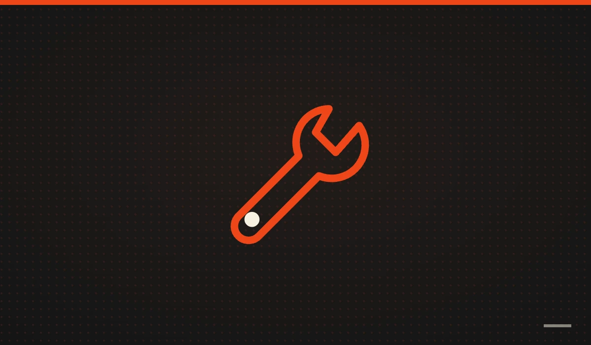 Llave inglesa naranja sobre fondo negro: mantenimiento web